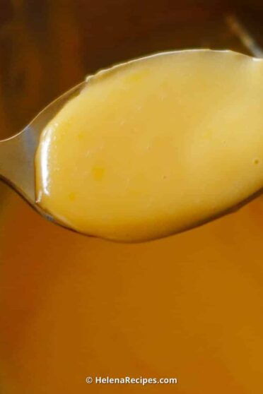 Hollandaise Sauce in a bowl with a full spoon of sauce.