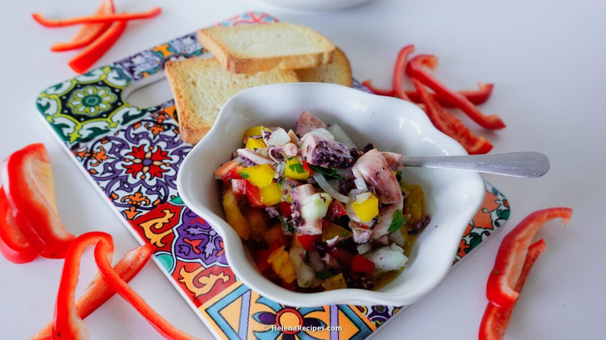 Octopus Salad on a plate with fresh peppers and crackers.