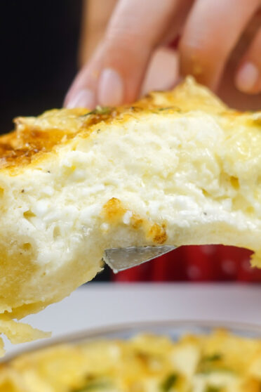 A closeup of camambert quiche in two hands