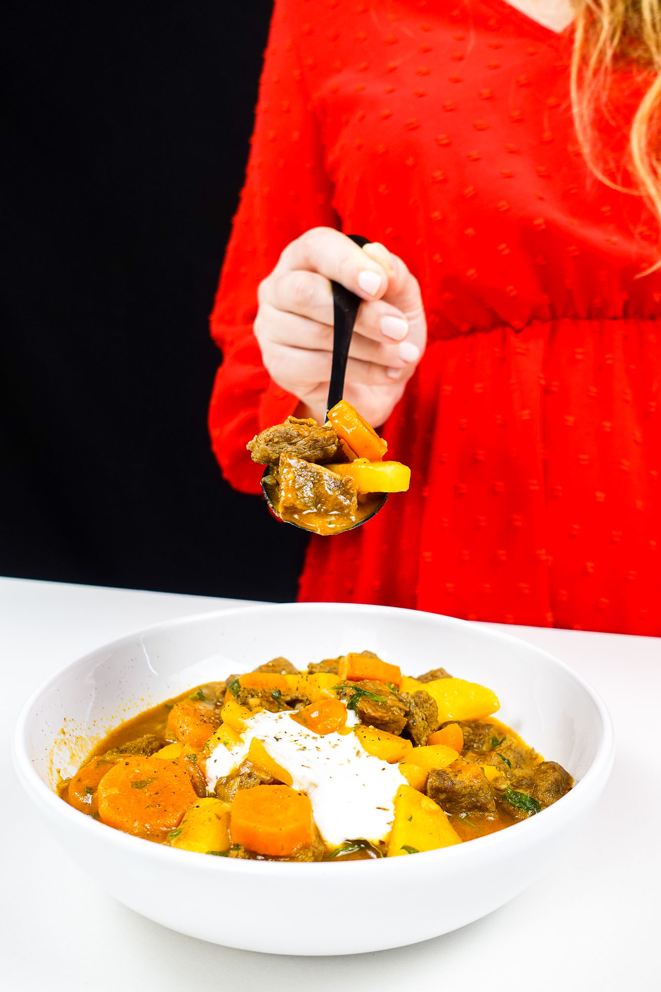 Beef Carrot Potato sew in a bowl with a spoon in Helena's hand