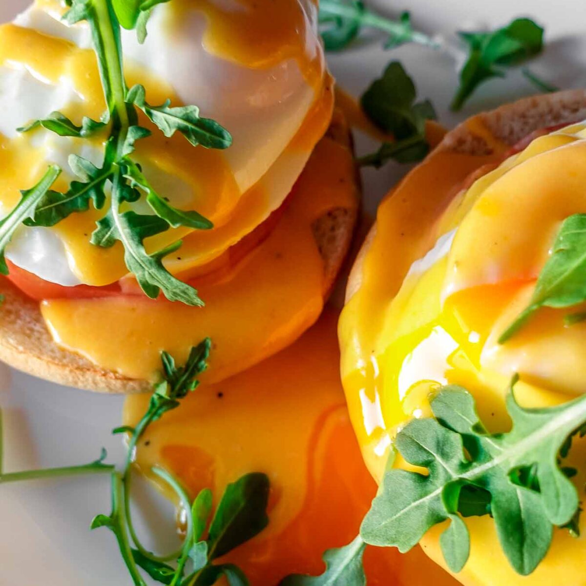 Caprese Eggs Benedict on a plate with arugula and running egg