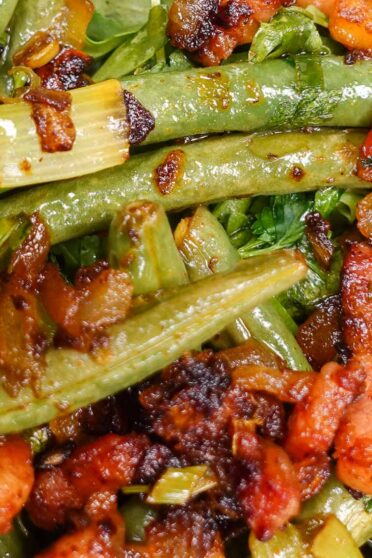 A closeup of French Green Beans with Bacon on a plate with a fork