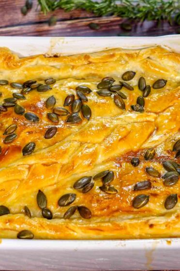 Baked leek and musroom pie in a form on a table.