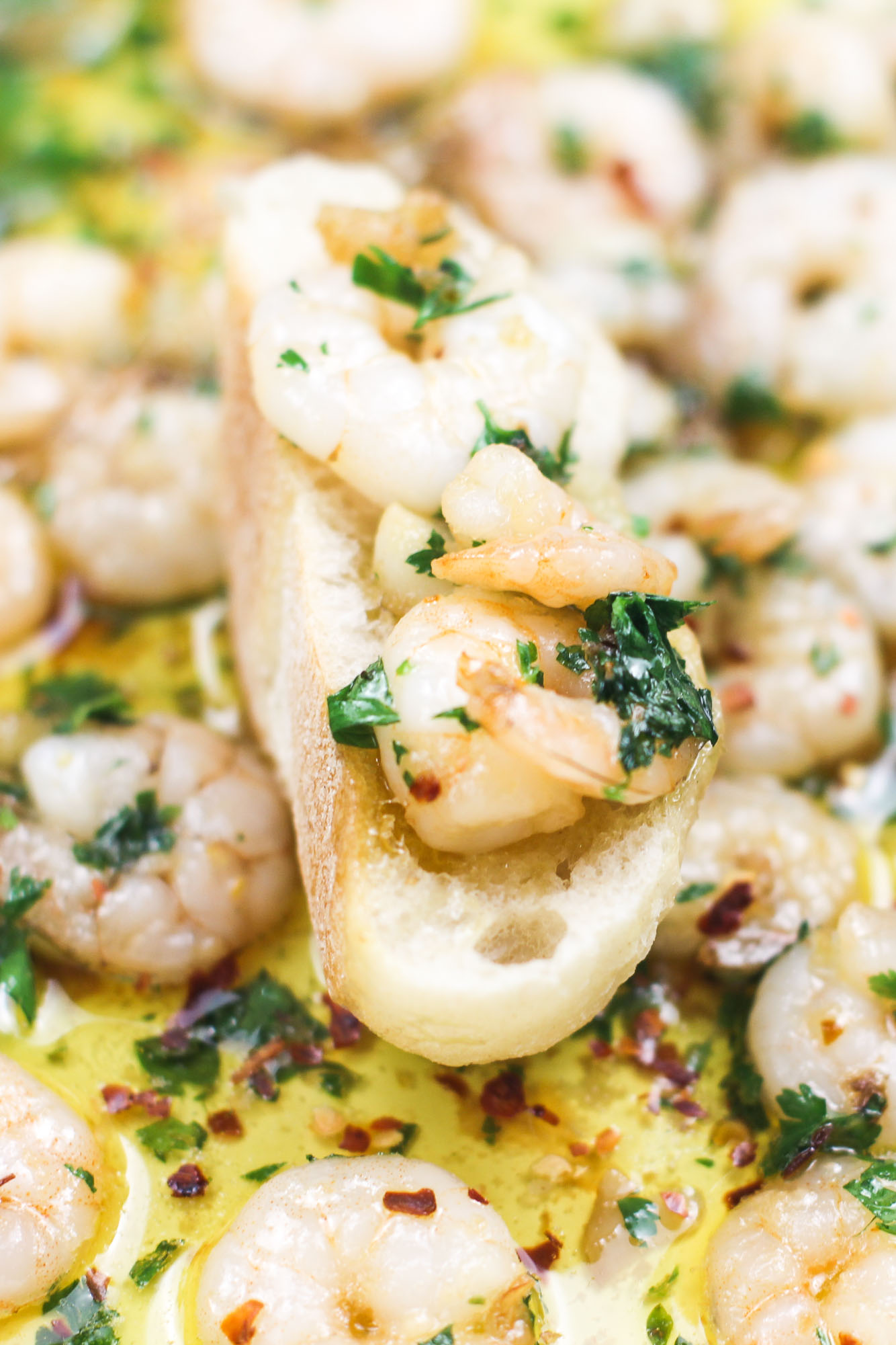 Shrimp in a pan with olive oil on a toast.