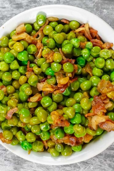 Mediterranean Peas with Bacon in a white bowl.