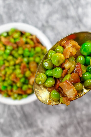 Delicious Mediterranean Peas with Bacon in a white bowl.