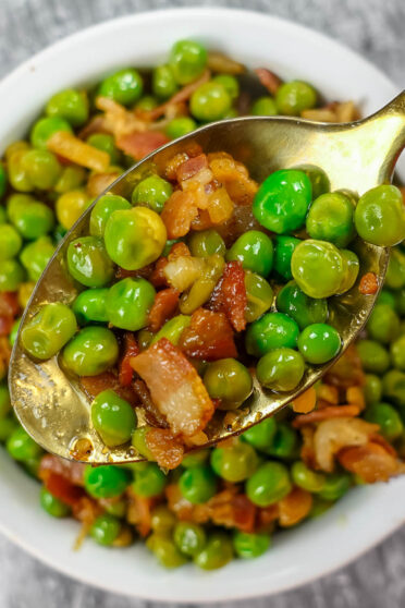 Delicious Mediterranean Peas with Bacon in a white bowl.