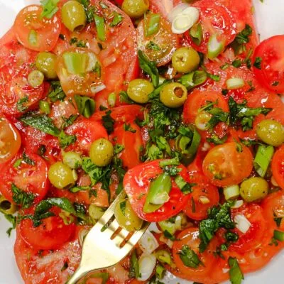 Tomato Salad on a plate and a fork full of salad.