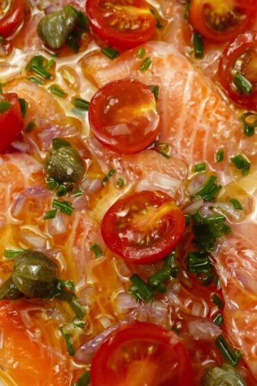 A closeup of delicious salmon on a plate with a small spoon