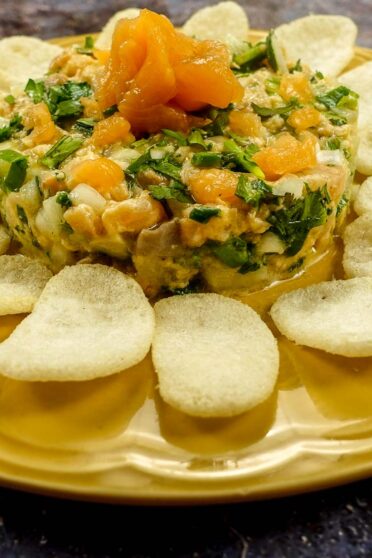 Mediterranean Salmon Tartare on a yellow plate with shrimp chips.