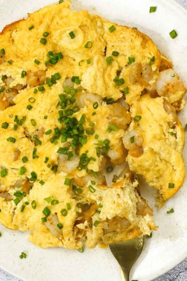 Shrimp Omelette on a plate with green onion.