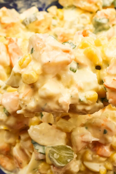A closeup of shrimp salad with a full spoon of salad.