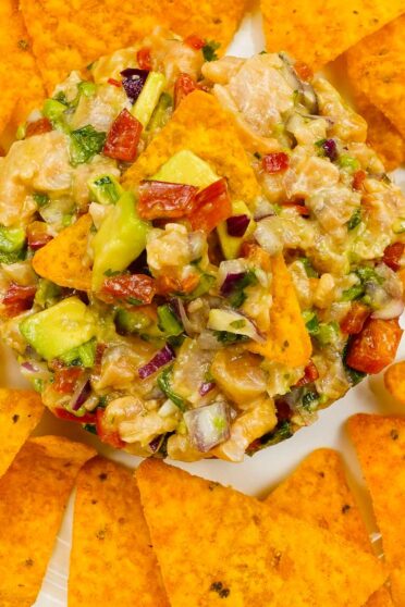 Spicy Salmon Tartare with Corn Chips on a yellow plate.
