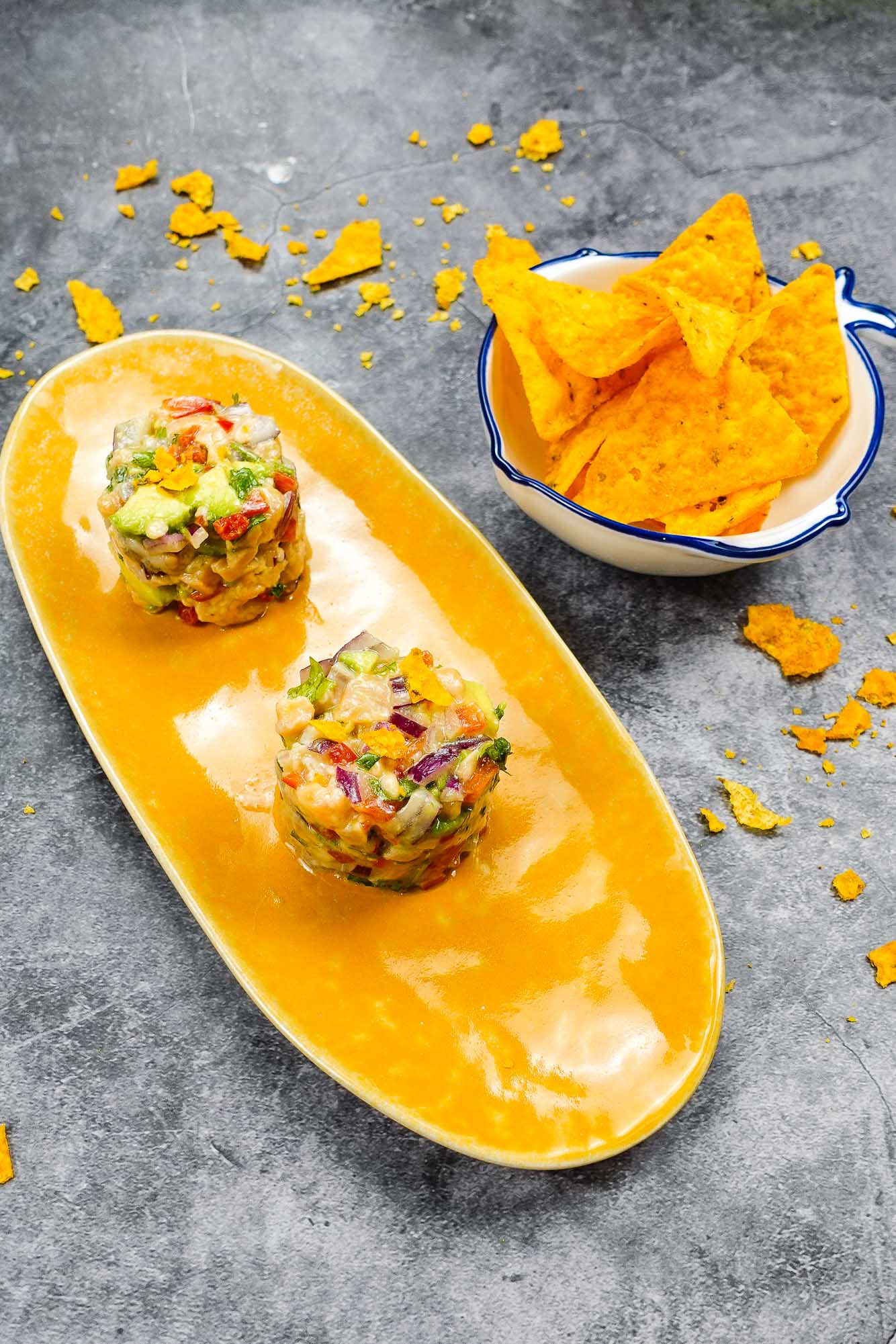 Spicy Salmon Tartare with Corn Chips on a white plate.