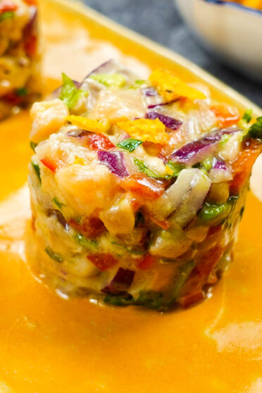 Spicy Salmon Tartare with Corn Chips on a yellow plate.
