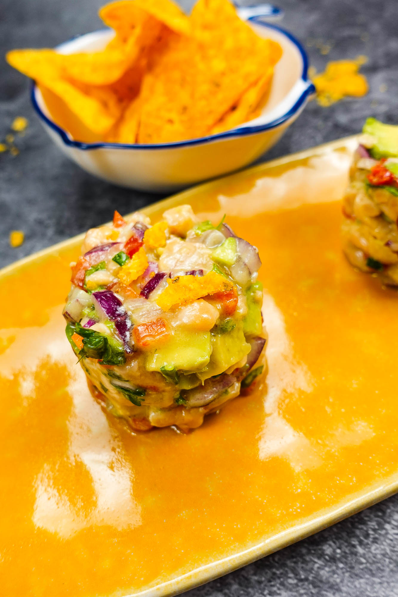 Spicy Salmon Tartare with Corn Chips on a white plate.