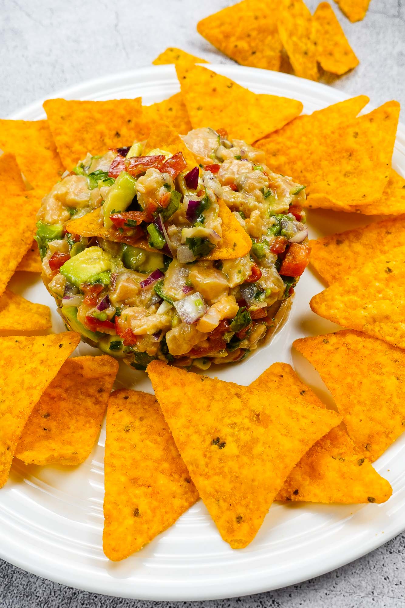 Spicy Salmon Tartare with Corn Chips on a white plate.