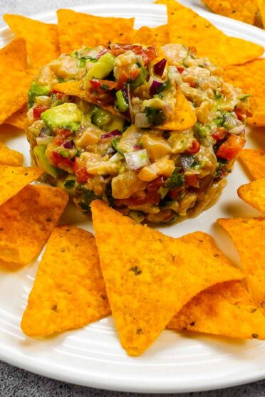 Spicy Salmon Tartare with Corn Chips on a white plate.