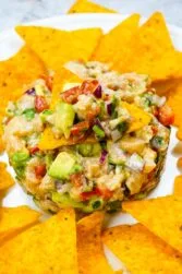 Spicy Salmon Tartare with Corn Chips on a white plate.