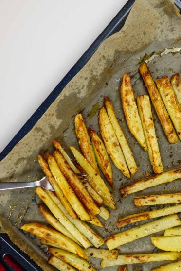 Holding a tray with potatoes just cooked from the oven.