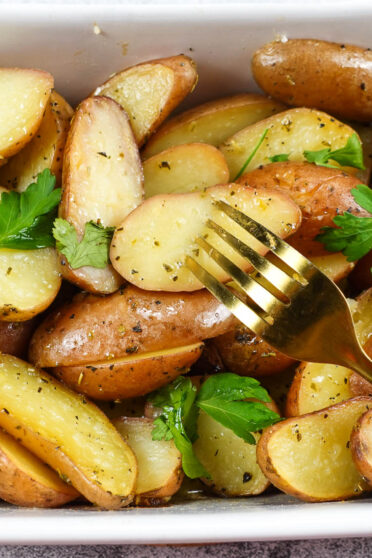 Mediterranean Baby Baked Potatoes in a skillet with fork.