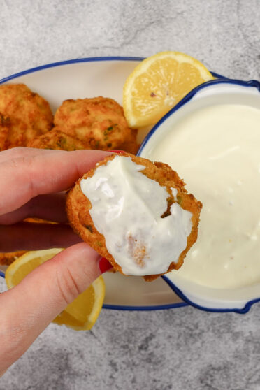 Dipping a ready made croquette into the sauce.