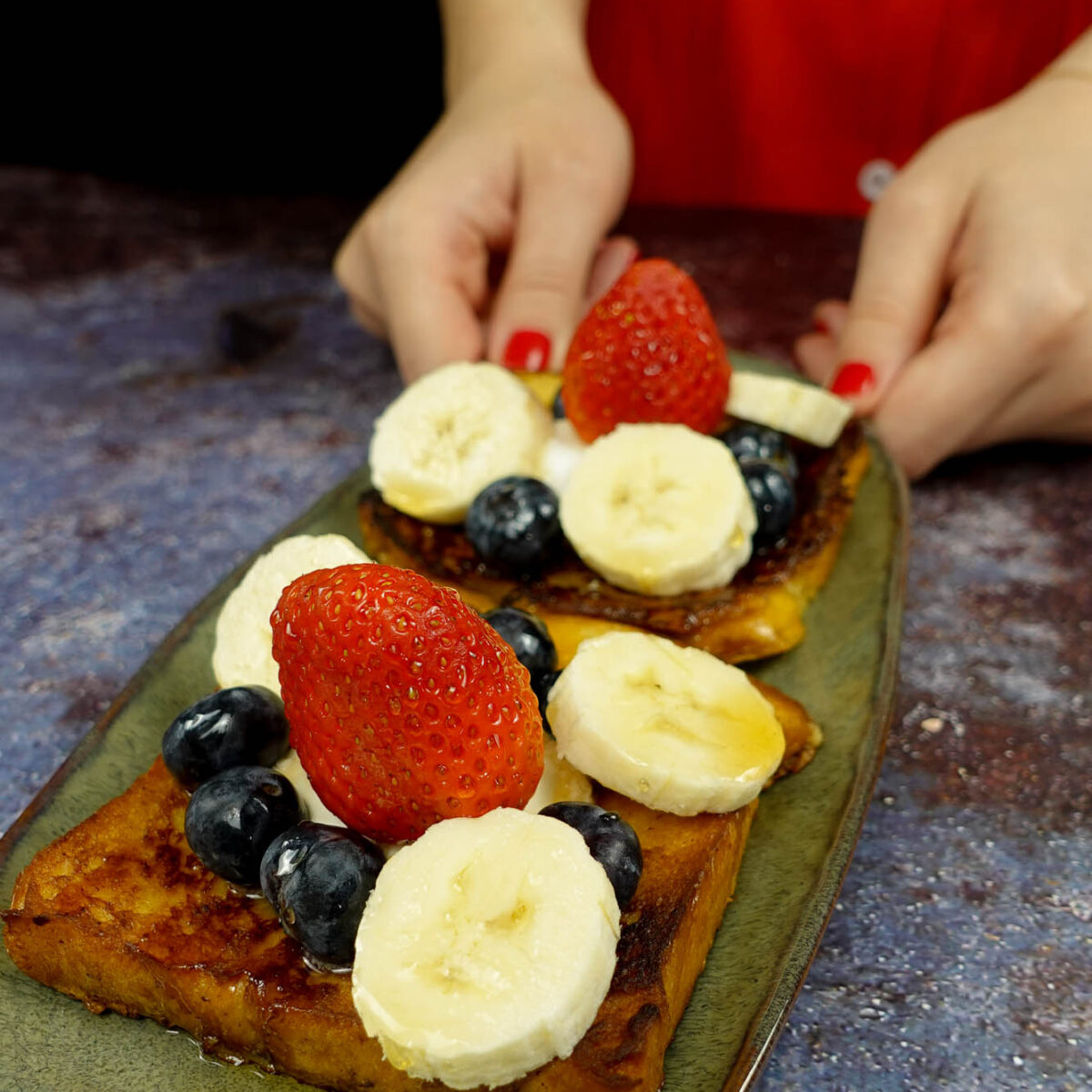 Delicious Cinnamon French Toast on a green plate in two hands