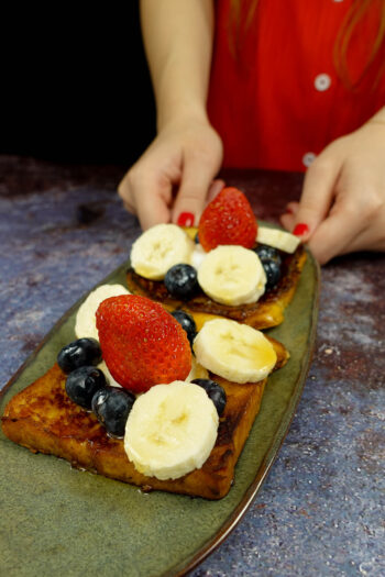 Delicious Cinnamon French Toast on a green plate in two hands