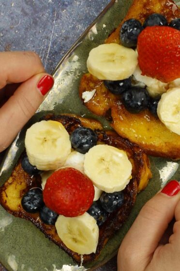 Cinnamon French Toast on a green plate in two hands