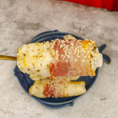 Mediterranean Baked Fish Fillets on a blue plate with a piece of flaky fish