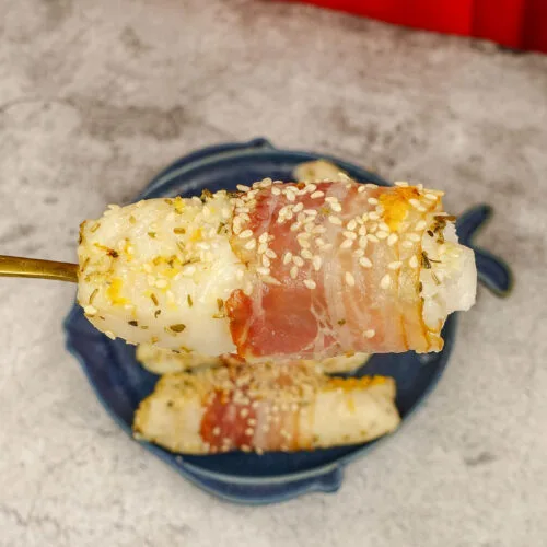 Mediterranean Baked Fish Fillets on a blue plate with a piece of flaky fish