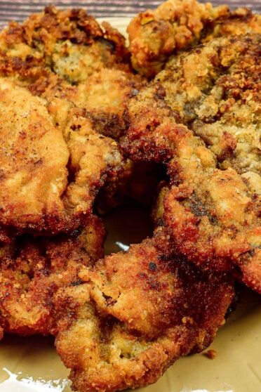 Yellow plate with breaded beef steak on a table