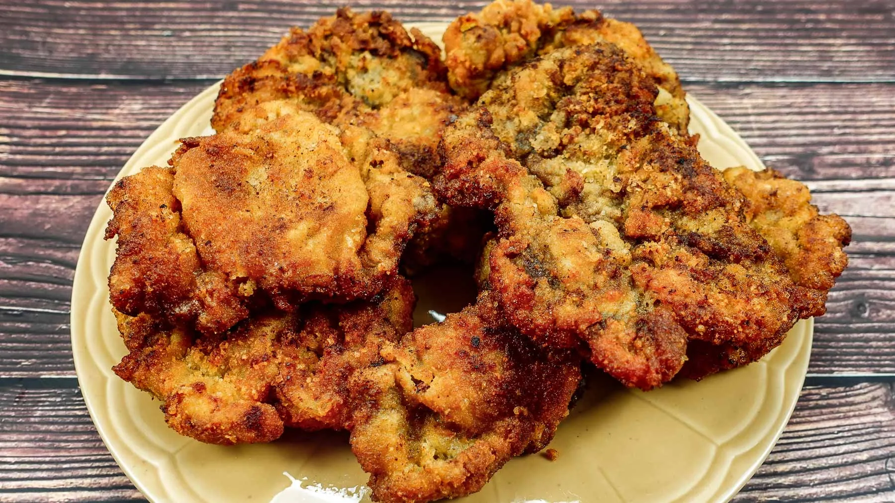 Yellow plate with breaded beef steak on a table