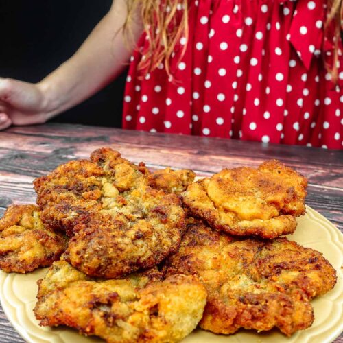 Helena is standing next to a plate with breaded beef steak