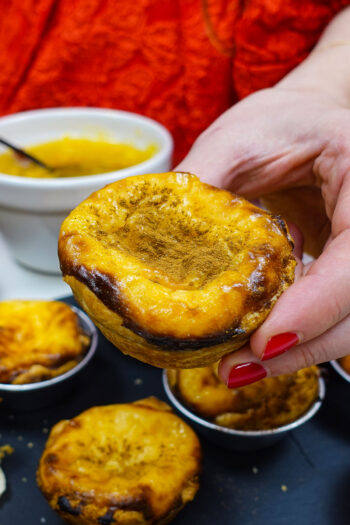 Holding a Pastel de Nata - one of the many Pastéis de Nata or Portuguese Custard Tarts made at home.