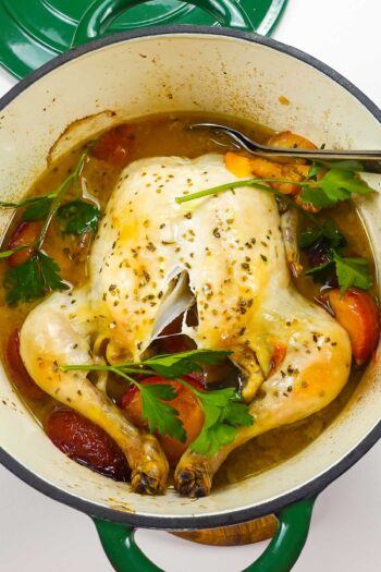 A dutch oven whole roast chicken with plums