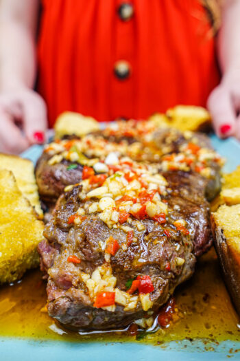 Helena is holding a blue plate with juicy Portuguese beef steak