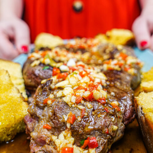 Helena is holding a blue plate with juicy Portuguese beef steak