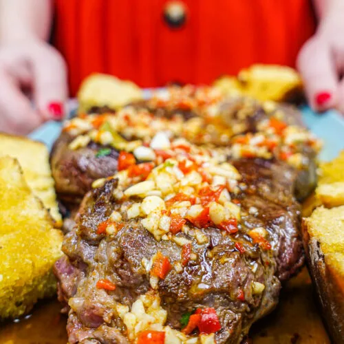 Helena is holding a blue plate with juicy Portuguese beef steak