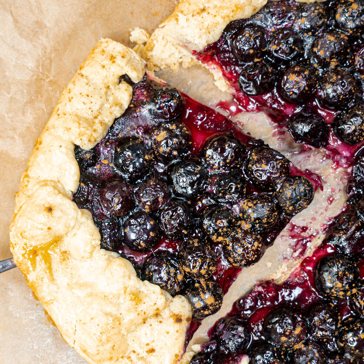 Sliced piece of Blueberry Crostata on a baking paper