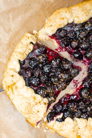 Sliced piece of Blueberry Crostata on a baking paper