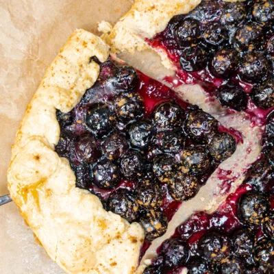 Sliced piece of Blueberry Crostata on a baking paper