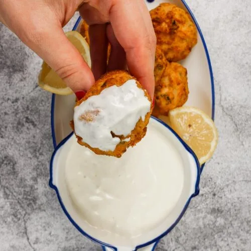 Garlic Yogurt Sauce with one shrimp croquette in one hand