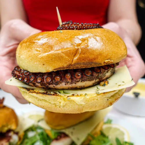 Helena is holding octopus burger in two hands