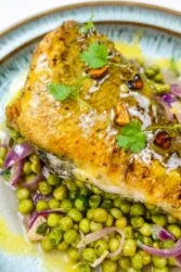 A closeup of beautiful sea bream with sauce and peas