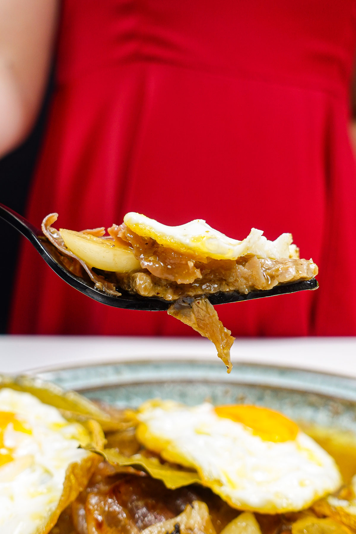 A piece of steak with fried egg on a fork