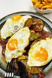 Portuguese Bitoque Steak with fried egg on a green plate