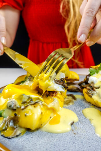 Helena is cutting croissant with truffles and hollandaise sauce