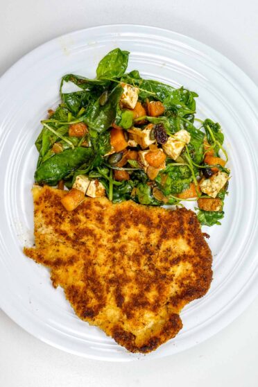 A photo of crunchy golden turkey cutlet with salad