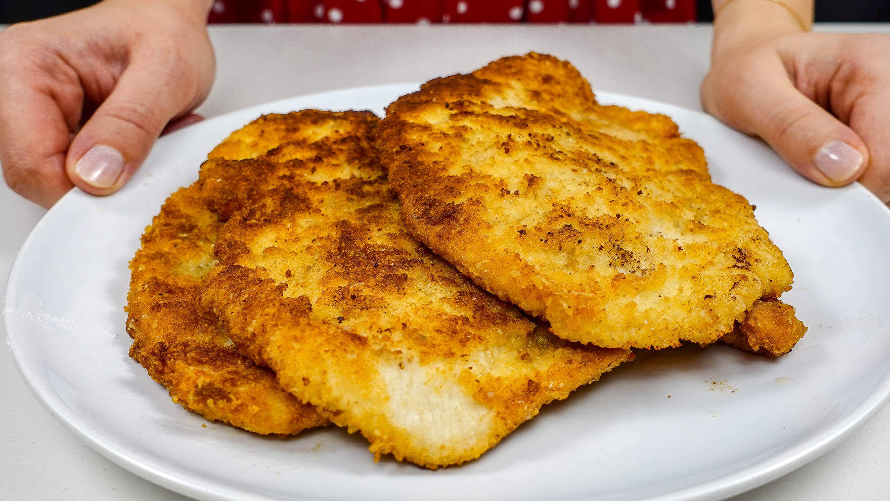 A plate with golden fried juicy turkey cutlets on a white plate